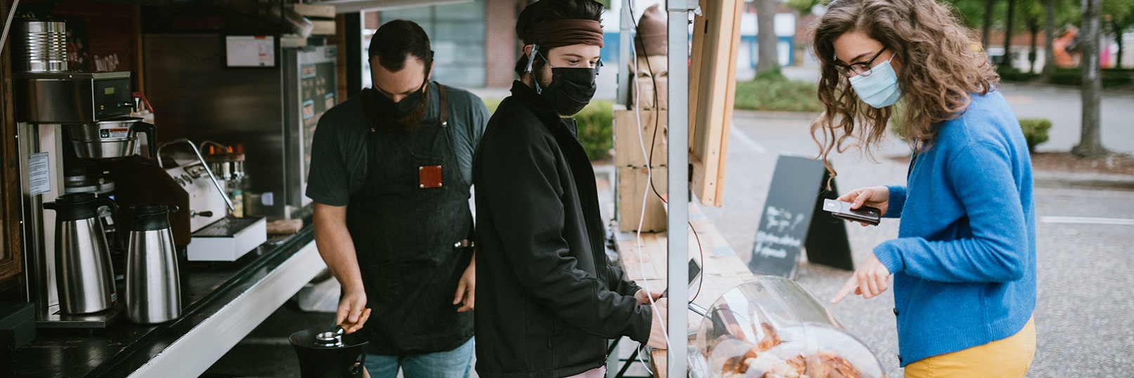 Woman in mask making purchase from outdoor vendor