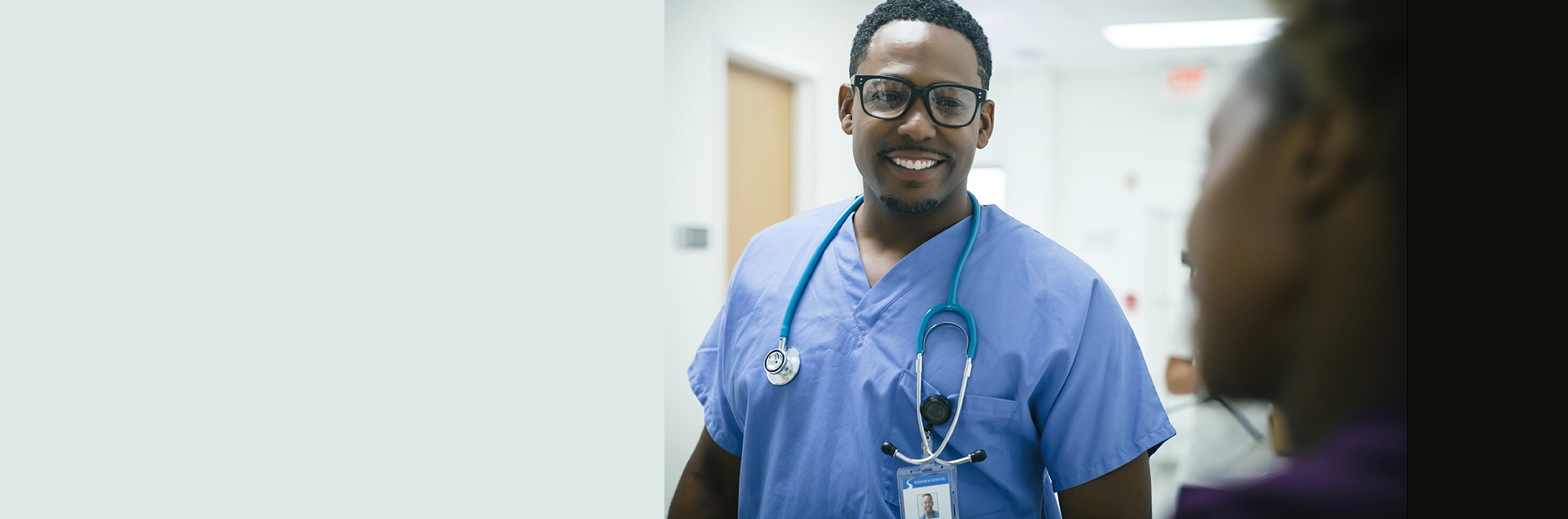 a black male doctor or nurse in a hospital hallway