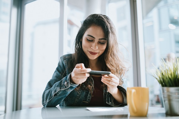 Woman taking picture of check with smartphone