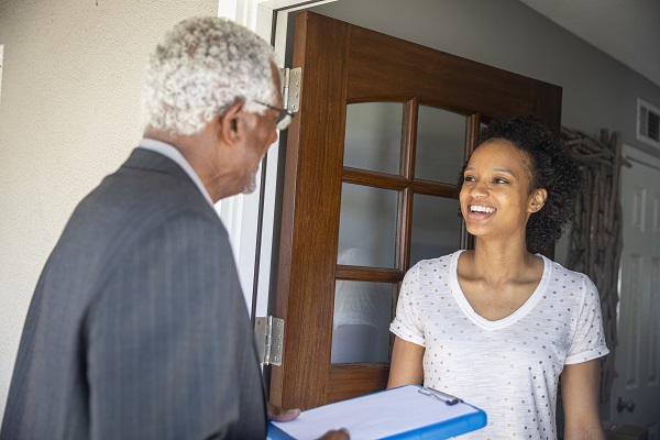 Surveyor greets woman at front door