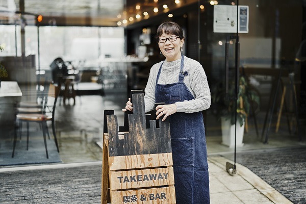 Female owner outside of her cafe