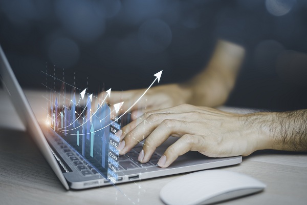 man working on laptop with chart visible