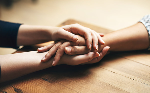 women holding hands across a table