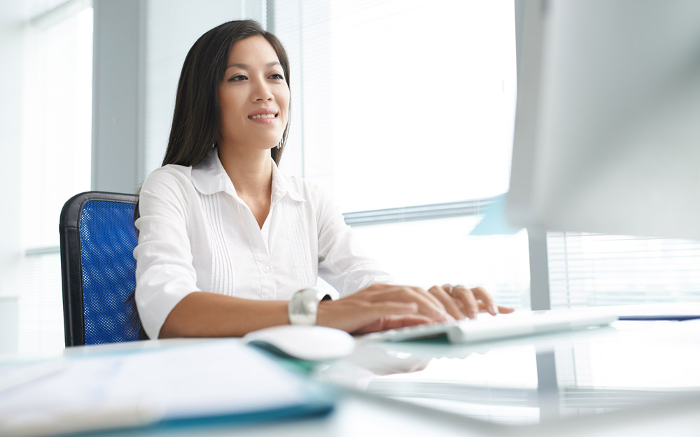 Asian Woman Typing at Computer