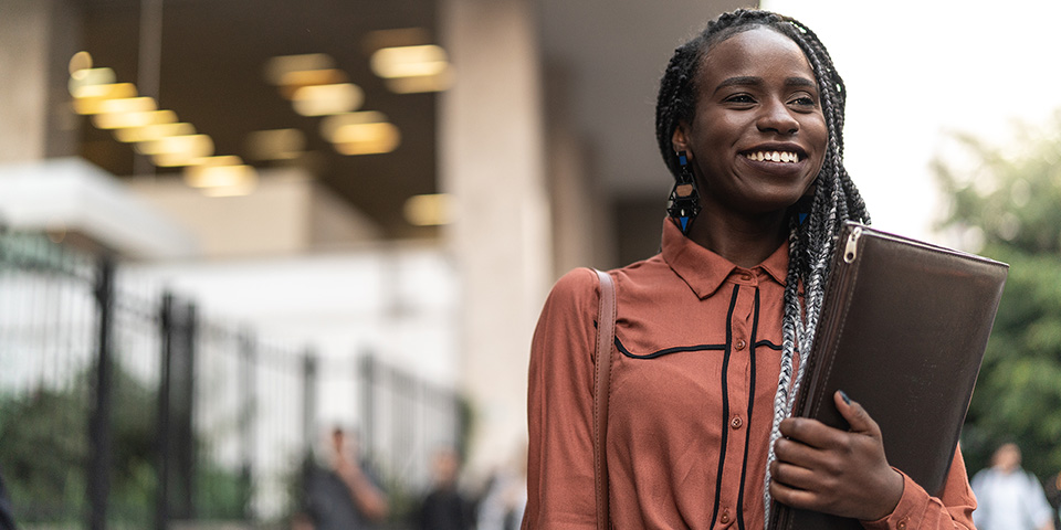 woman smiling and holding a binder