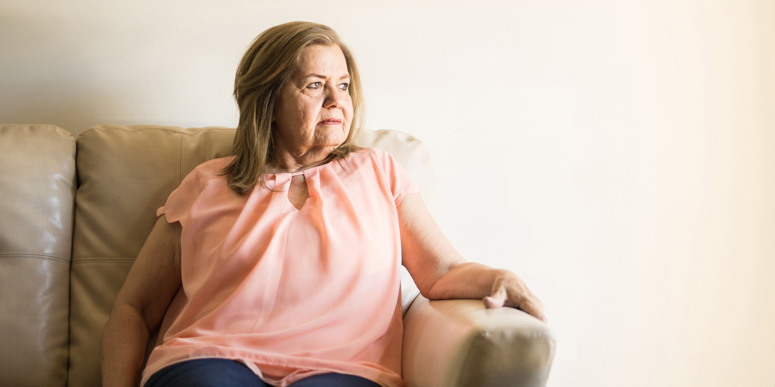 a woman sitting on a sofa, looking to the side