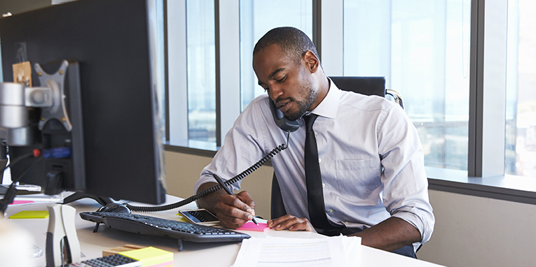 man at desk on the phone