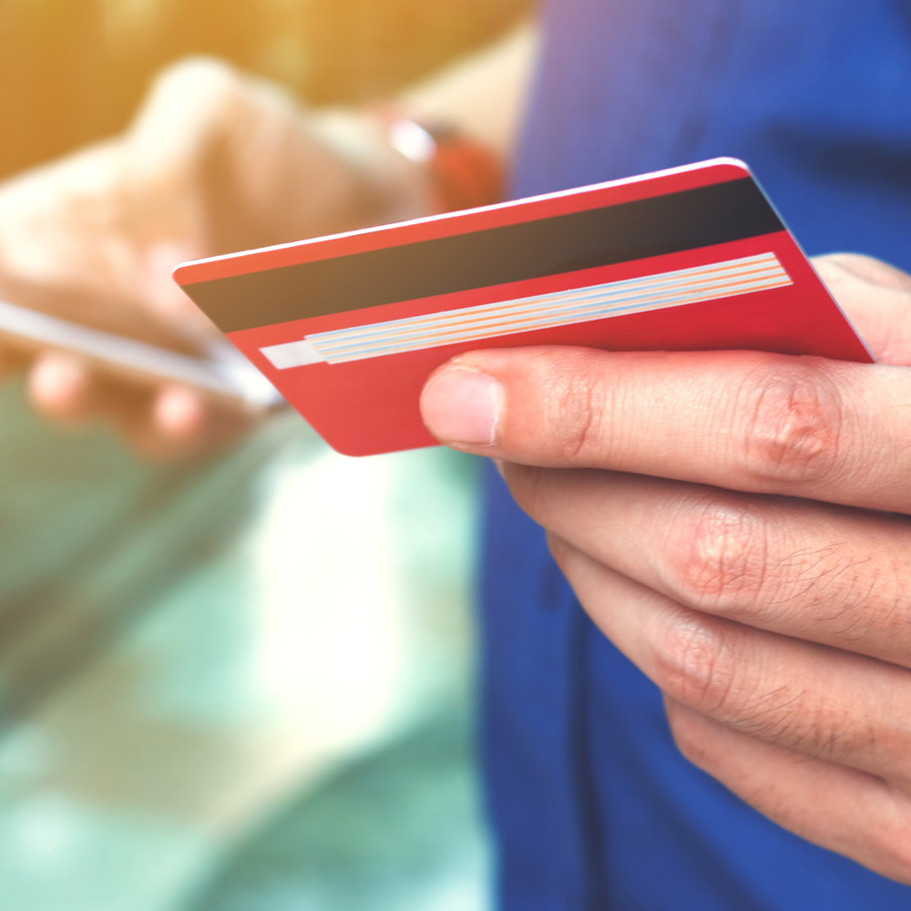 Close-up of a man's hand holding a debit card