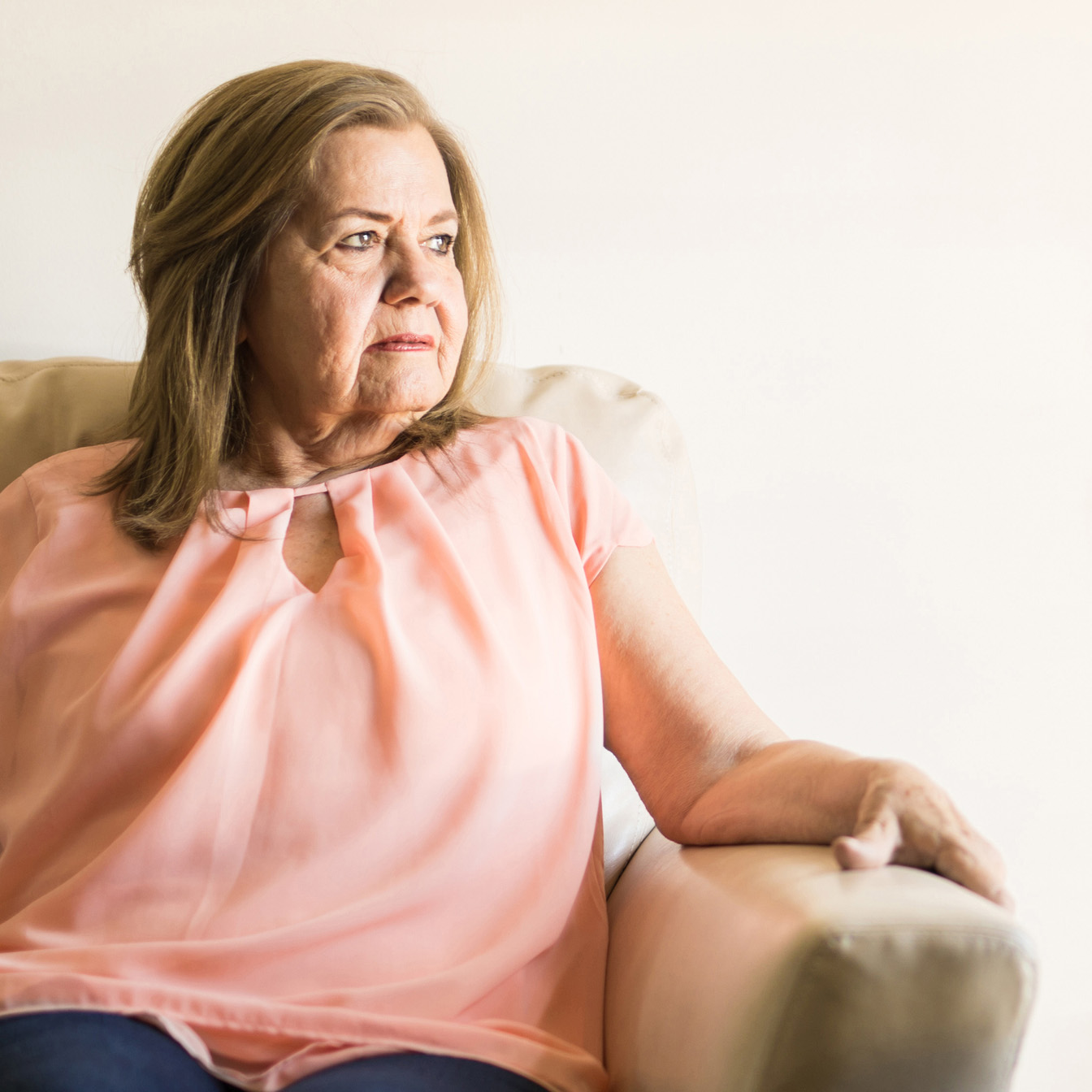 a woman sitting on a sofa, looking to the side