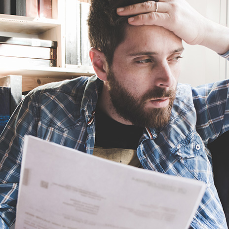 a man with his hand to his forehead, opening mail