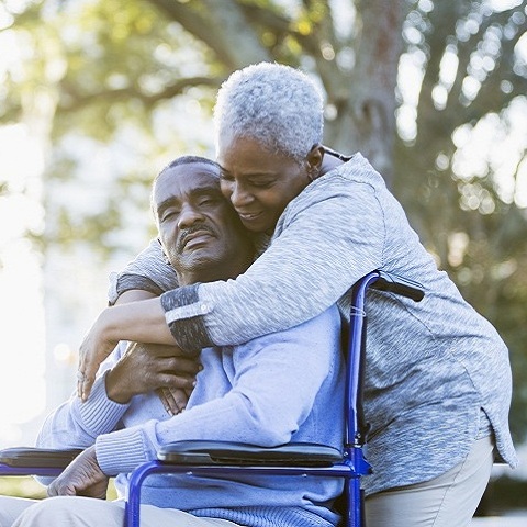 woman standing behind man in wheelchair