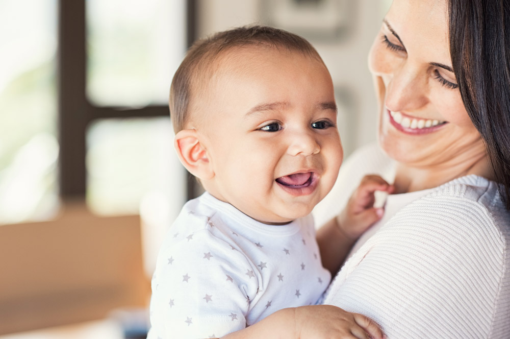 Happy mother holding smiling baby