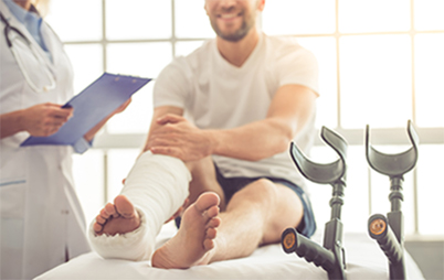 A man with cast on his leg visiting with doctor