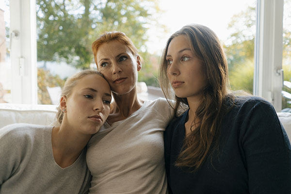 woman and her daughers sitting on a couch 