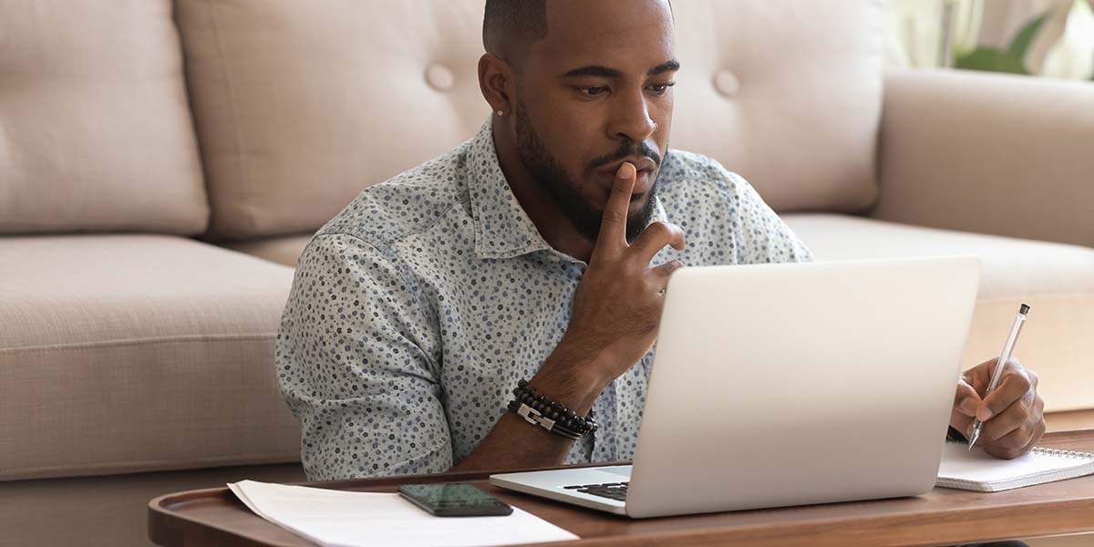 a man at home looking at his laptop computer