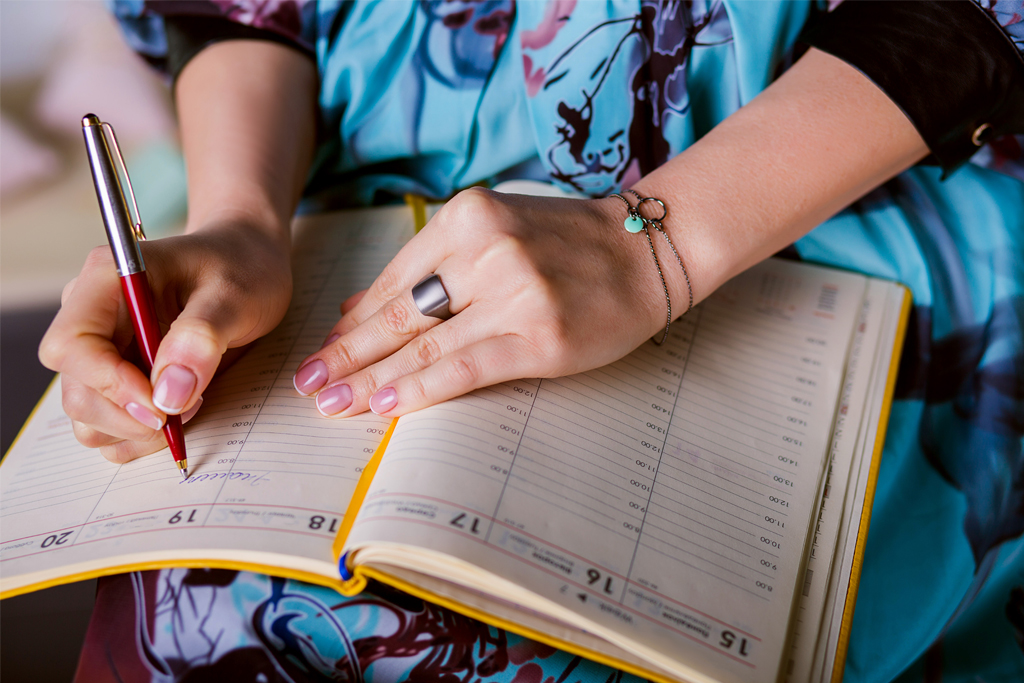 woman writing in a calendar