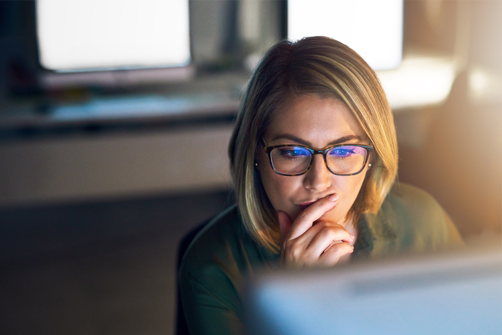 woman looking thoughtfully at a computer