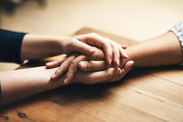 a closeup of two people's hands clutched together