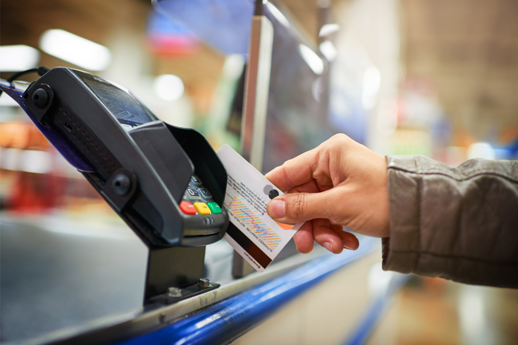 person using a debit card at a supermarket checkout
