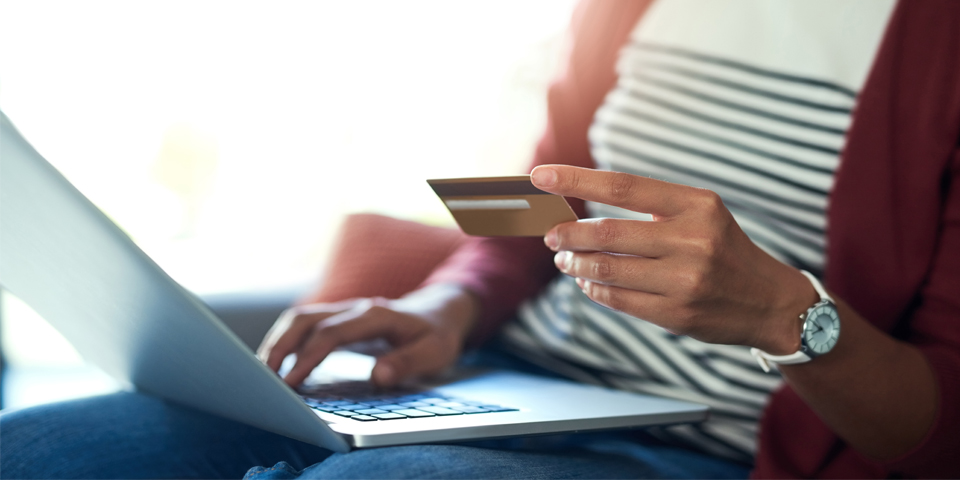 woman with a debit card and laptop