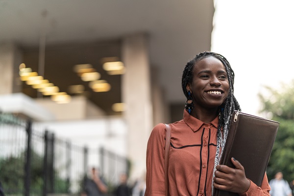 Professional woman smiling holding binder