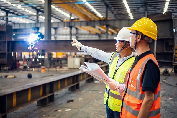 Two men in conversation at manufacturing facility