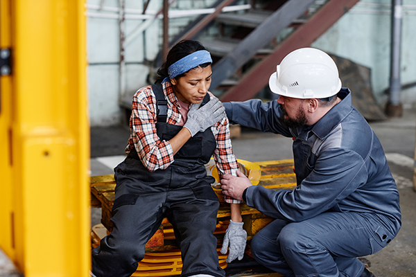 an injured construction worker being tended to by a coworker