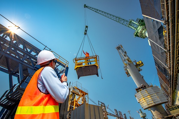 worker on radio guiding crane