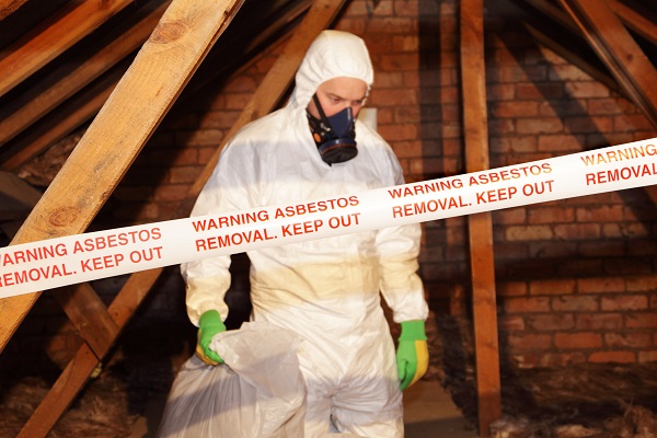 a worker wearing protective clothing while clearing hazardous in an attic