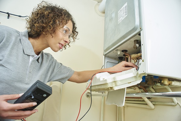 a female technican testing a heating boiler