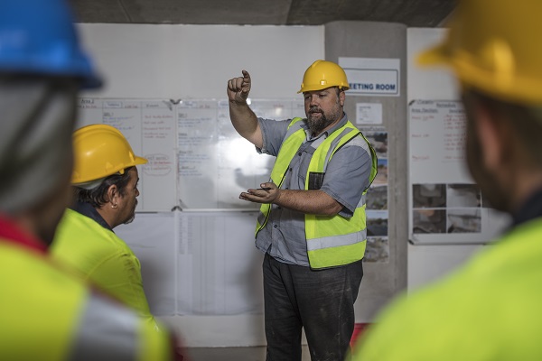 Trainer in hard hat demonstrating at training session