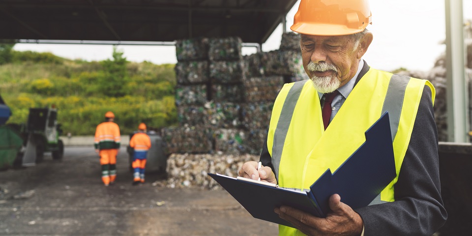 Man in hardhat at recycling facility