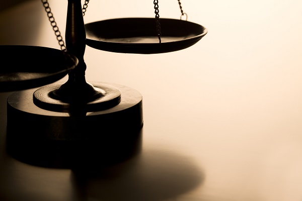 Scales of justice with back-light on wood table.