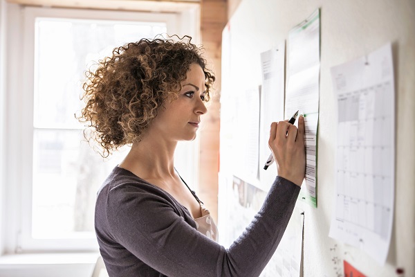 Woman staring at flyers on bulletin board