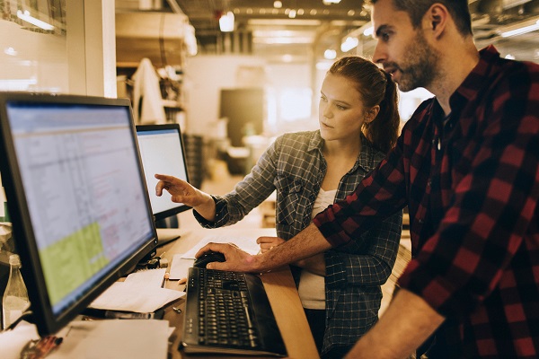 Man and woman working at desktop computer together