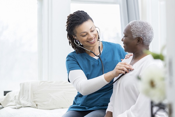 Woman listening to heartbeat of older woman