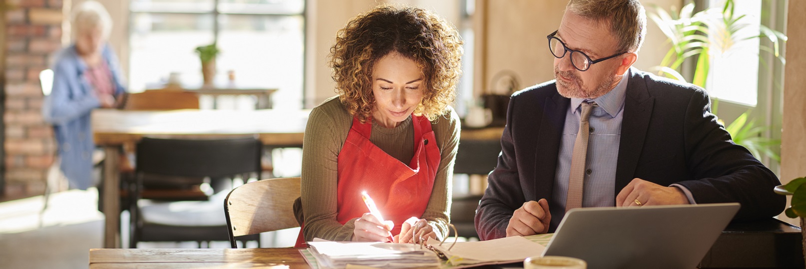 Woman in apron signing the agreement 