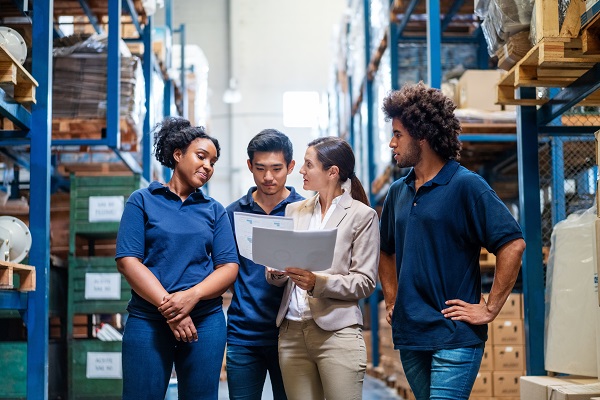 Female manager in discussion with staff in warehouse