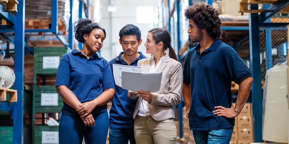 Female manager in discussion with staff in warehouse