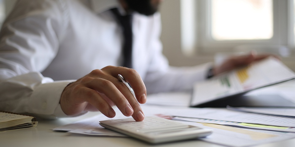Man at desk with calculator