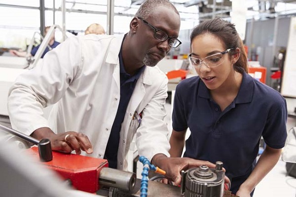 Female technician guiding a young female trainee in a workshop