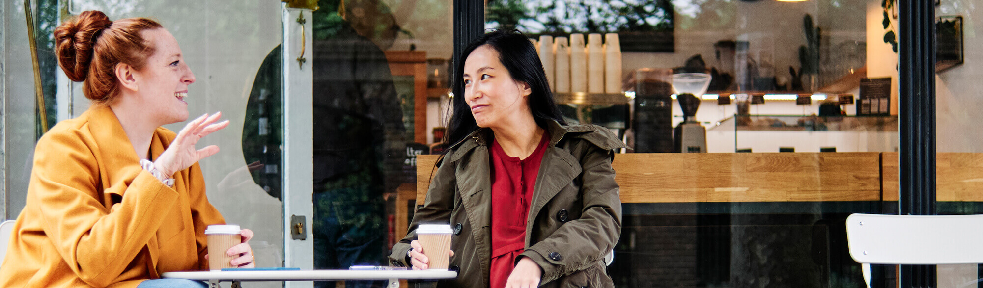 Two girls having coffee outside the cafe