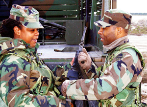 Spc. Lisa Easley (left), 150th AG Detachment, receives a safety briefing from Sgt. Joseph Thorpe (right) before heading to the firing line with her M-249.