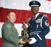 Col. Michael Cunniff (left) Commander, 108th Air Refueling Wing, presents Master Sgt. Donald G. Newlin, Sr. (right) with a trophy during the 108th's Family Day awards ceremony July 17. Newlin has been with the Honor Guard Program since its inception. Photo by Staff Sgt. Barb Harbison, 108 ARW/PA.