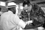 Master Sgt. James McCloskey (right), 177th Fighter Wing Medical Group takes a veteran's blood pressure during Stand Down 2005.