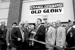The Adjutant General, Maj. Gen. Glenn K. Rieth, along with members of various veterans' organizations watch as Governor James E. McGreevey (center) prepares to cut the ribbon officially opening the Old Glory Wing at the New Jersey Veterans Memorial Home at Menlo Park on April 30.