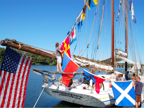 The crew of the A.J. Meerwald, NJ's Official Tall Ship, hoists colorful pennants into the rigging while docked at Trenton