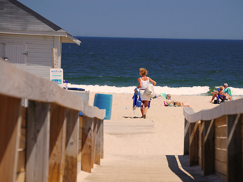 A woman looks for a good spot to relax as she enters the beach at Ocean Grove