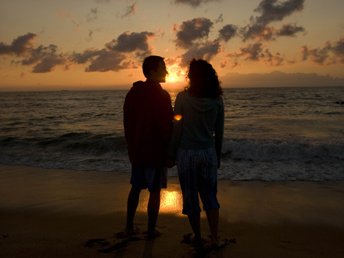 Couple enjoying a glorious sunrise at the Jersey shore