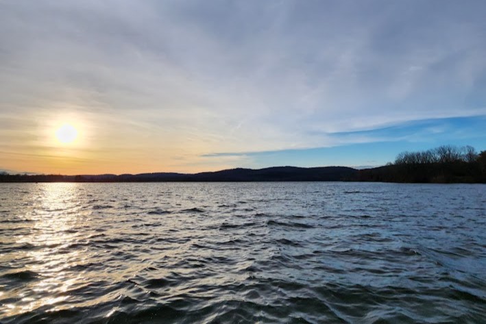 spruce run sun on horizon line of blue water